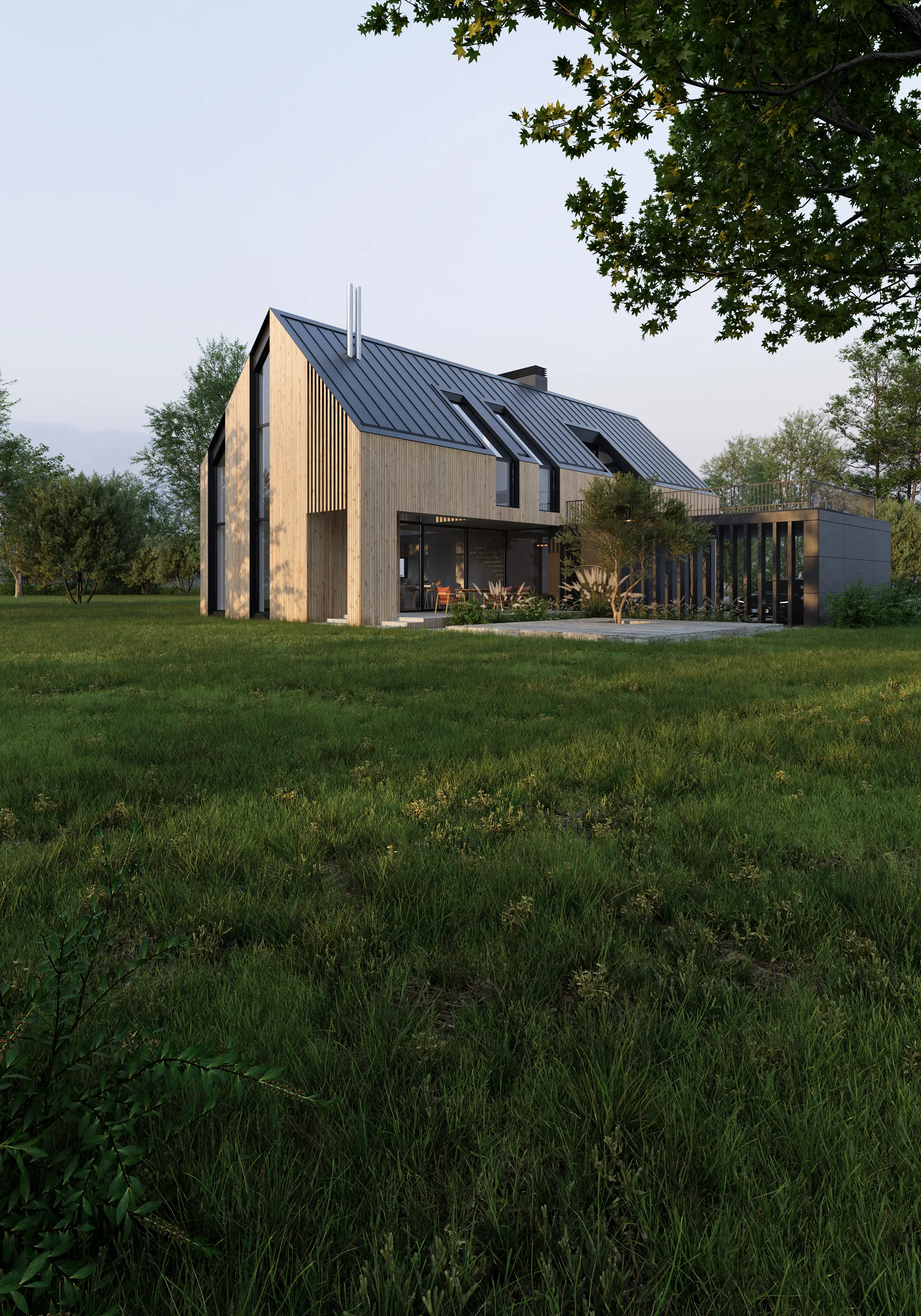 Pale timber Green Harbor house with a dark metal roof, standing in a green meadow at dusk.